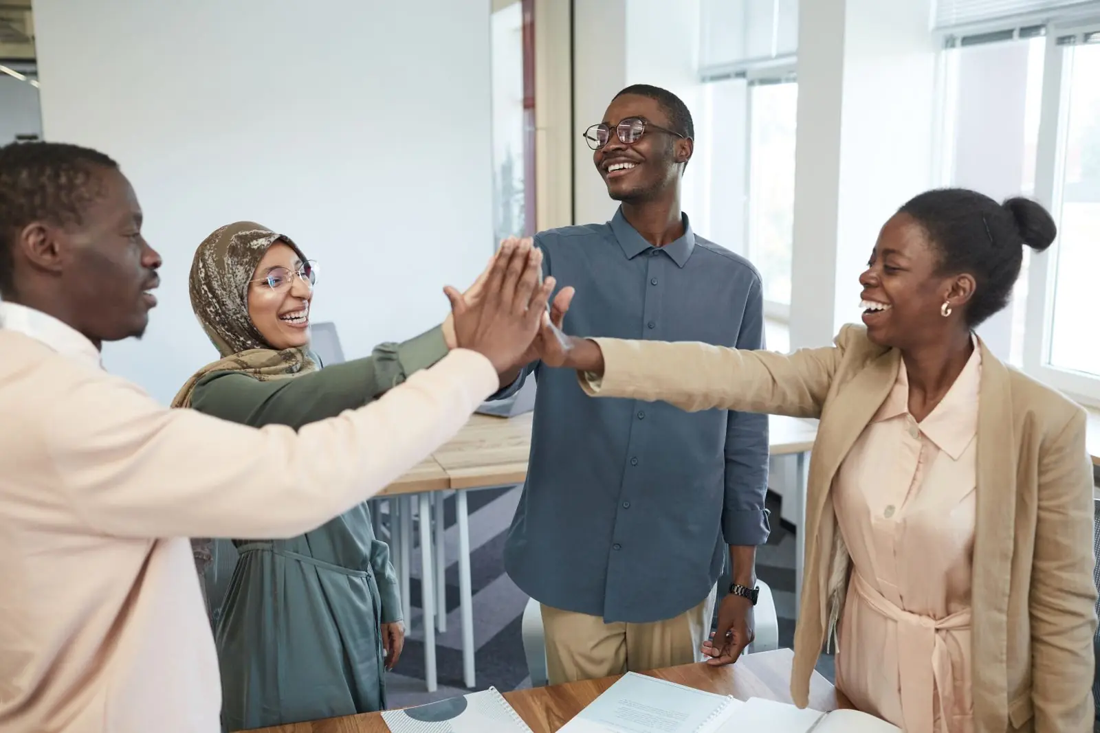 Des collègues se tapent dans la main pour fêter une réussite dans leur bureau