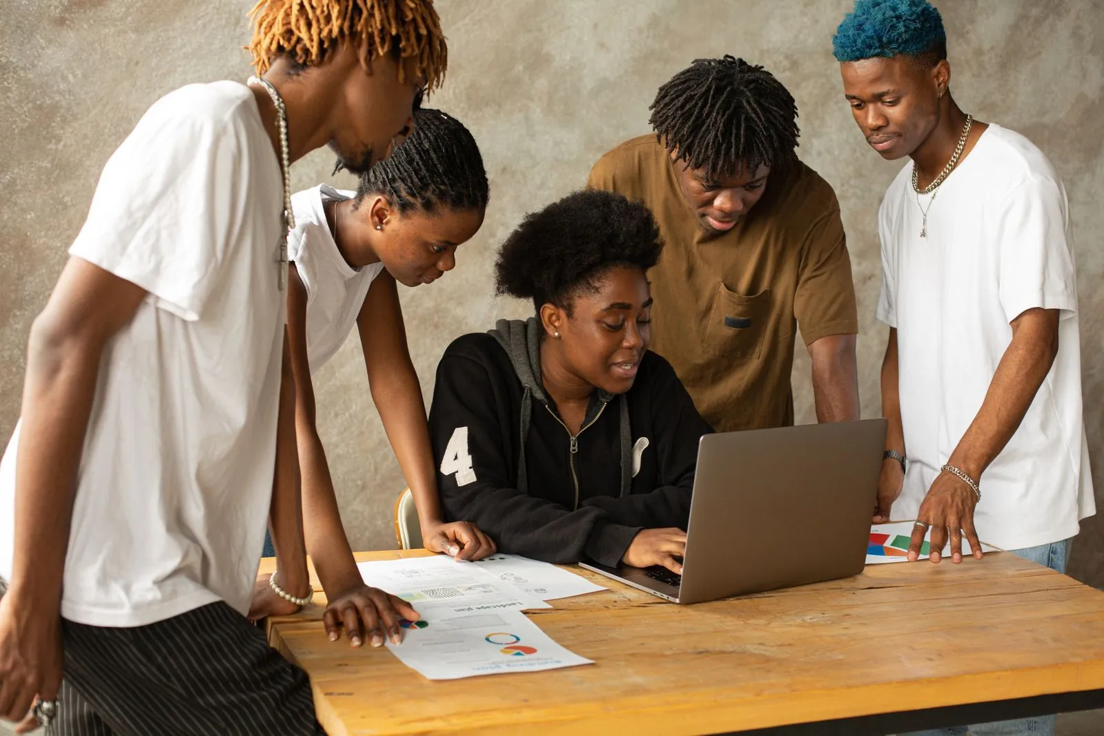 Une équipe de jeunes professionnels travaille autour d'un ordinateur portable